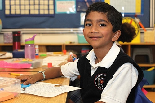 male student at desk in classroom