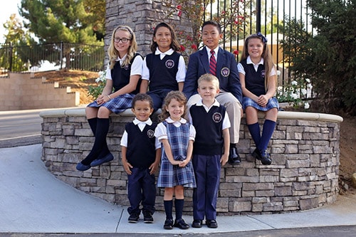 Students sitting outside on rock wall