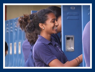 Female student laughs as she opens a locker